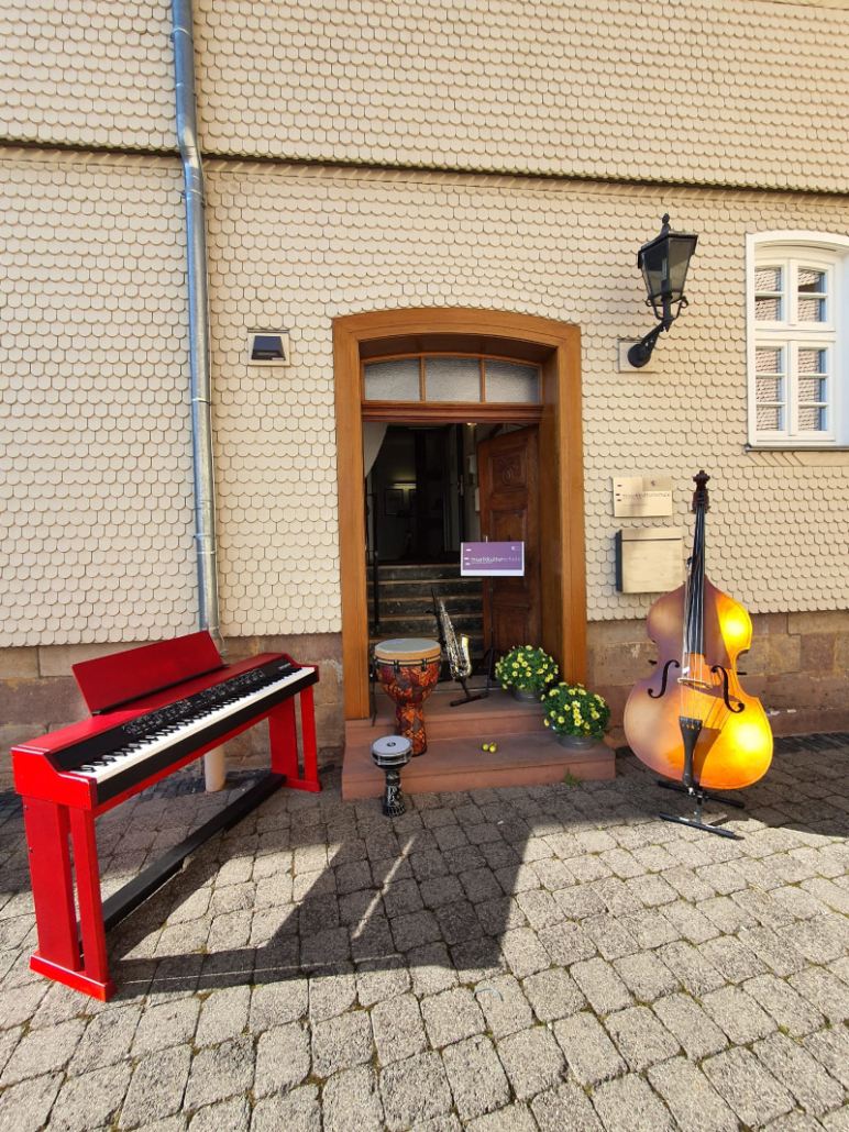 Eingangsbereich der musikkulturschule, der Musikschule im Altern Esel in Lauterabach, im Vordergrund E-Piano, Schlaginstrumente, Saxophon, Kontrabass und ein Notenpult